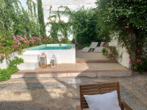 uma piscina com dois candeeiros e um banco e flores em Patios del Agua em El Puerto de Santa María