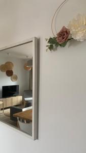 um espelho numa sala de estar com uma flor na parede em Apartament Vintage em Mrągowo