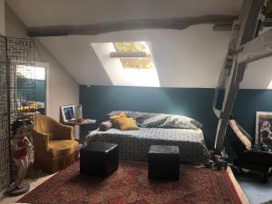 ein Schlafzimmer mit einem Bett und einem Stuhl in der Unterkunft Grande maison avec jardin arboré in Survilliers