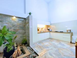 a kitchen with a stone floor and a brick wall at Nạp Homestay in Kinh Dinh