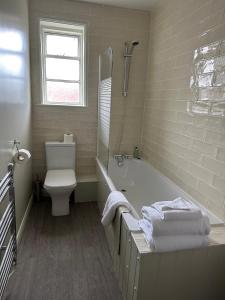 a bathroom with a tub and a toilet and a sink at The Goddard Arms in Swindon