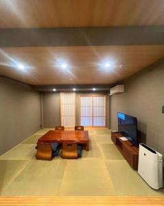 um quarto com uma mesa e uma televisão de ecrã plano em 千本南大阪で日本の伝統的な文化を感じられる雰囲気 em Osaka