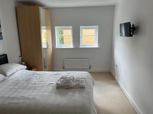 Un dormitorio con una cama con dos pares de zapatos. en Hampton Vale, Peterborough Lakeside Large Double bedroom with own bathroom en Peterborough