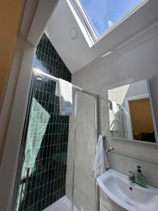 a bathroom with a shower and a sink and a mirror at Oranhill Lodge Guesthouse in Oranmore