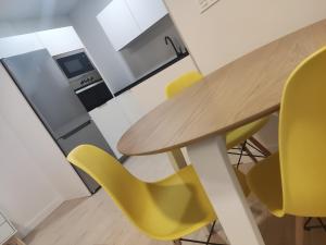 an office with a wooden table and yellow chairs at Txoko Loft Moncayo in Tudela +2 photos