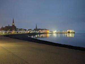 a view of a city at night with the water at Mustard Seed 43 Seamore Street 1/L Largs in Largs