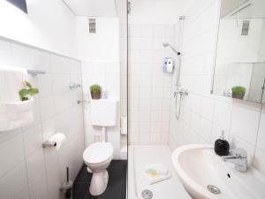 Un baño blanco con inodoro y lavabo. en Zentrale & gemütliche Wohnung mit Sonnenbalkon, en Essen 14 fotos más