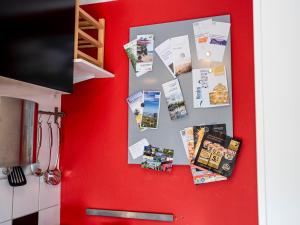 Una pared roja con un montón de papeles encima en Zentrale & gemütliche Wohnung mit Sonnenbalkon, en Essen