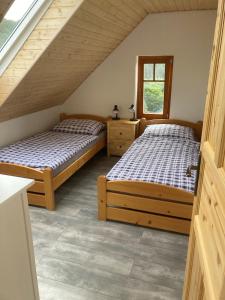 2 camas individuales en una habitación con ventana en Pension Pošta, en Branná