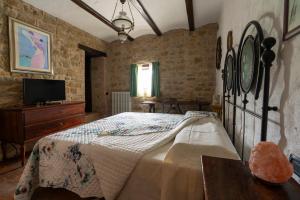 1 dormitorio con 1 cama y TV en Villa Lucia - Homelike Villas, en Camporotondo di Fiastrone