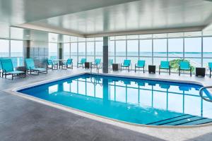 a pool in a hotel with blue chairs and tables at Residence Inn by Marriott Ocean City in Ocean City