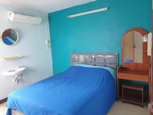 a blue bedroom with a bed and a sink at Roong-Arun Apartment in Bangkok