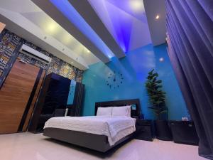 1 dormitorio con cama y pared azul en Skeyndor Health & Resort en Na Jomtien