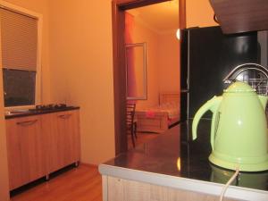 a kitchen with a green kettle on a counter at Guest House Ukimerioni in Kutaisi