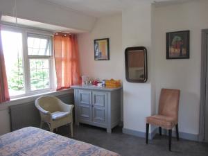 una camera da letto con cassettiera, specchio e sedie di de Flesch a Dodewaard
