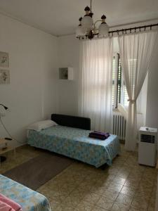 a bedroom with a bed and a window with curtains at Clara Luna appartamento turistico in Osimo