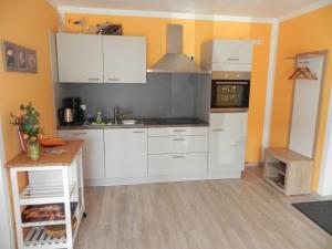 kuchnia z białymi szafkami i zlewem w obiekcie Villa Bettina - Ferienwohnung 04 w mieście Heringsdorf