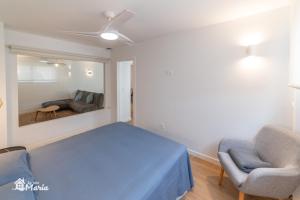 a bedroom with a blue bed and a couch at La Iaia Maria in Gandía