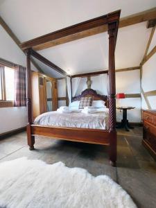 a bedroom with a canopy bed with a white rug at Barnacre Green Cottage with Hot Tub and Private Pool in Moreton