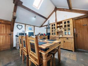 a kitchen with a wooden table and wooden cabinets at Barnacre Green Cottage with Hot Tub and Private Pool in Moreton
