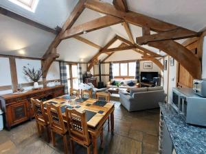 a living room with a wooden table and chairs at Barnacre Green Cottage with Hot Tub and Private Pool in Moreton