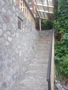 un escalier en pierre menant à un mur en pierre dans l'établissement Cabanuta Ancutei, à Rucăr