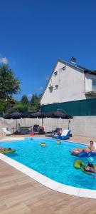 a group of people laying in a swimming pool at Gästehaus Kathi GyenesCamping Wohnwagen Knaus 1 Rechts in Gyenesdiás +16 photos