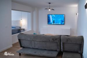 a living room with a couch and a television on the wall at La Iaia Maria in Gandía