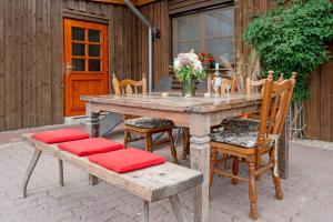 una mesa de madera y sillas con flores en el patio en Dat Süselhuus, en Süsel