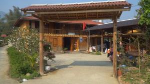 a wooden building with a pavilion in front of it at Pook Homestay in Ha Giang +17 photos