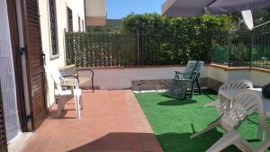 a patio with lawn chairs and an umbrella at Appartamento Martina in Rapolano Terme