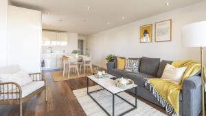 a living room with a couch and a table at MODERN LUXE APT just 10 MINS from TOWER BRIDGE! EASY ACCESS TO TUBE AND BUS in London