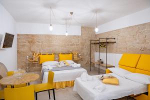 a room with two beds and a table and chairs at PALAZZO NICOLAUS del BORGO ANTICO in Bari