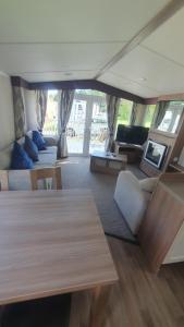 a living room with a couch and a table at Caravan 66 Kensington at Marton Mere Holiday Park Blackpool in Blackpool