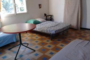 a small room with a bed and a table and a table at Petite maison de pays in Hourtin
