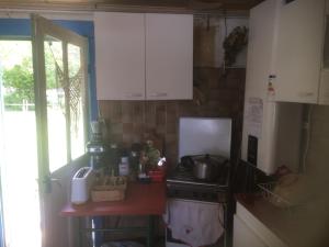 a kitchen with white cabinets and a stove top oven at Petite maison de pays in Hourtin