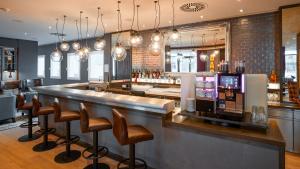 a bar in a restaurant with stools at Premier Inn Nürnberg City Opernhaus in Nuremberg