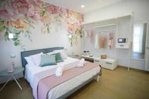 a bedroom with a bed with a flower mural on the wall at StabiaHome City and Sea in Castellammare di Stabia