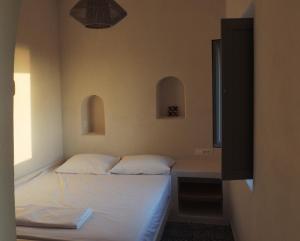 VourvoúlosにあるVilla Apaggio Santoriniのベッドルーム1室(ベッド2台、窓付)