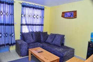 a living room with a purple couch and a table at Four seventy in Meru