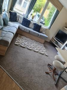 a living room with a couch and a large window at Caravan Kensington 46 at Marton Mere Blackpool in Blackpool