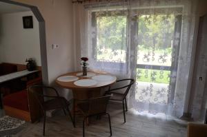a table and chairs in a room with a window at Agroturystyka u Hani in Wola Niżna