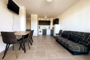 a living room with a couch and a table at Esprit du Sud - Terrasse & Parking in Brignoles