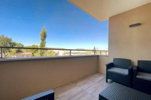 a balcony with two chairs and a view of the ocean at Esprit du Sud - Terrasse & Parking in Brignoles