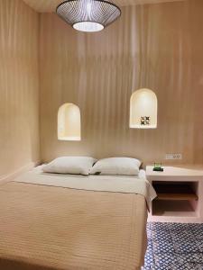 VourvoúlosにあるVilla Apaggio Santoriniのベッドルーム1室(壁に照明2つ付)