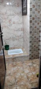 La salle de bains est pourvue d'une douche et de toilettes. dans l'établissement Dhanwantri Niwas, à Varanasi