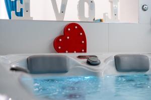 a bath tub with a red heart on the wall at PALAZZO NICOLAUS del BORGO ANTICO in Bari