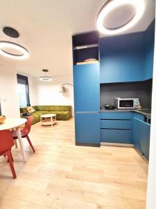 uma cozinha com armários azuis e uma sala de estar em PROMENADE SEA SIDE APARTMENT em Herceg Novi