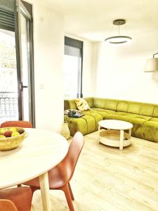 uma sala de estar com um sofá verde e uma mesa em PROMENADE SEA SIDE APARTMENT em Herceg Novi