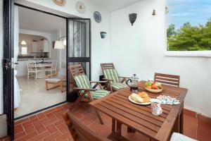 patio con mesa de madera y sillas y cocina en Casablanca 46 Oasis Properties, en Nerja